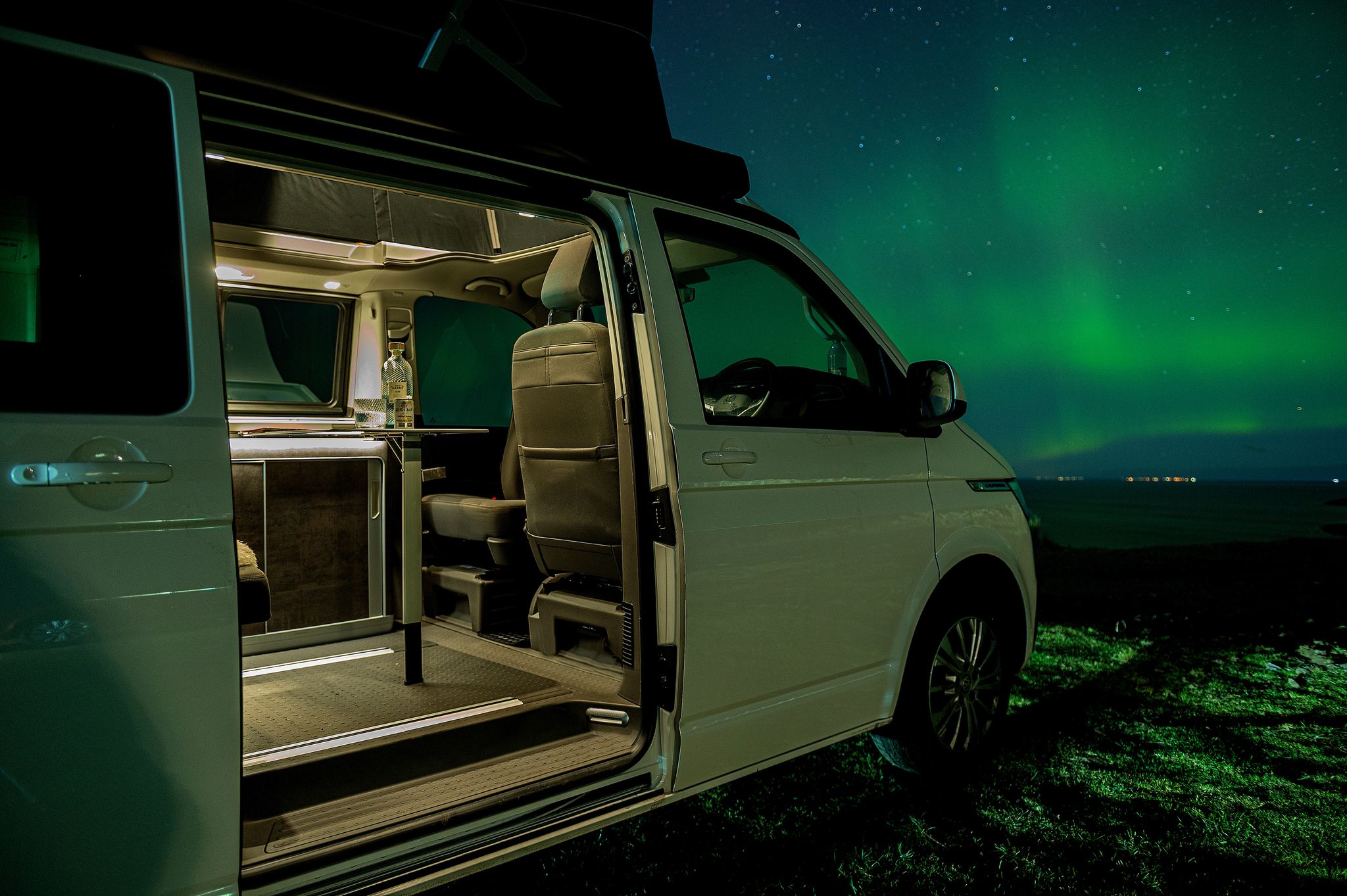A campervan at Gairloch in Wester Ross with the Northern Lights visible beyond