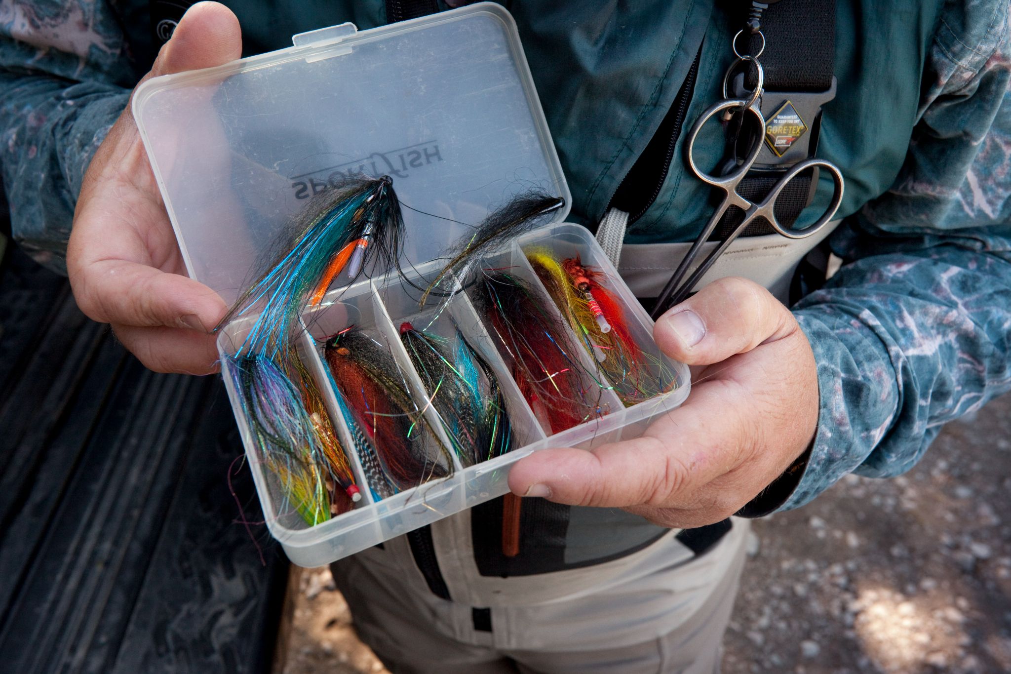 An angler with a box of fishing flies on the River Dee.