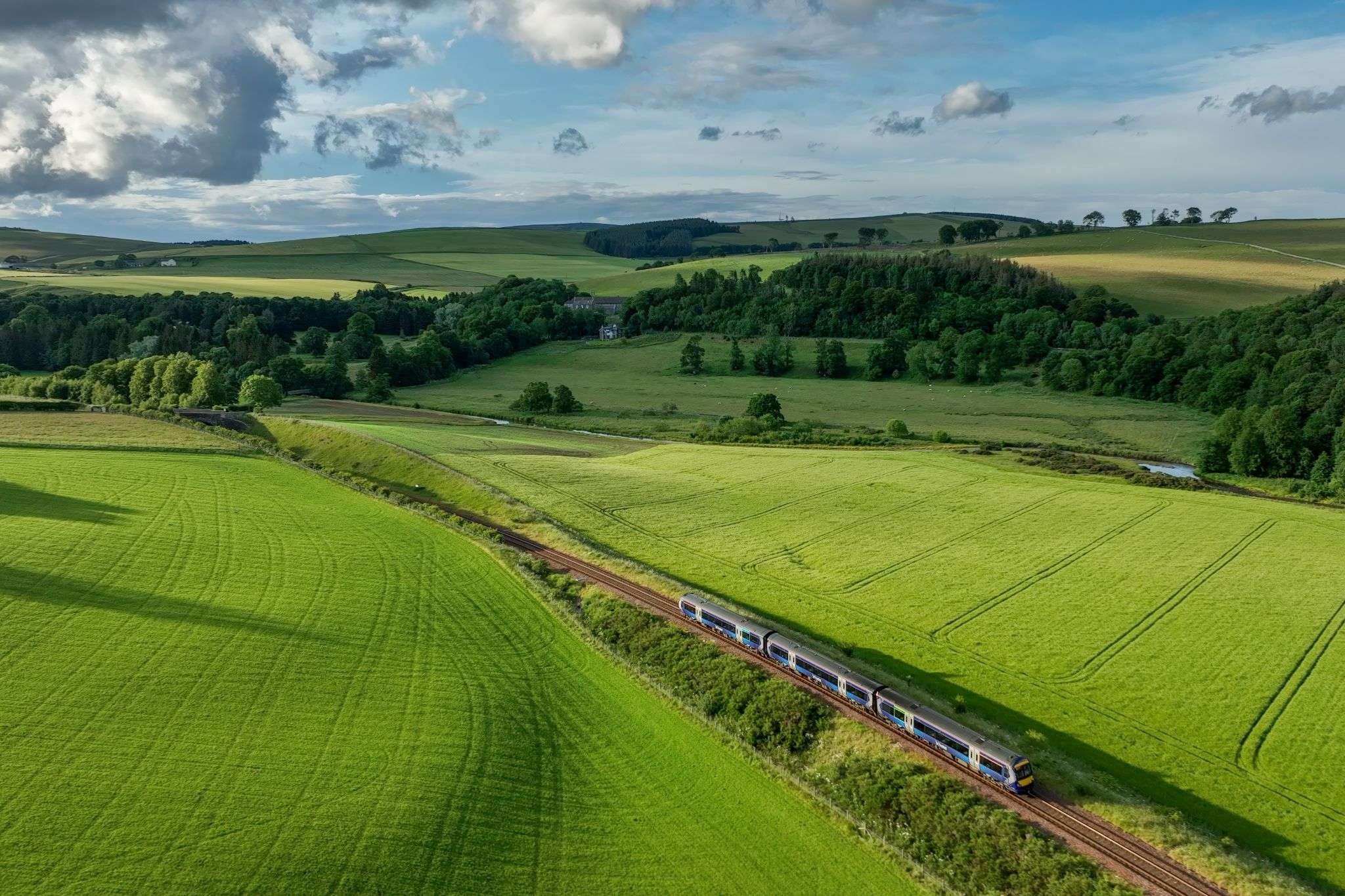 ScotRail train passing through the rolling hills landscape of The Scottish Borders.